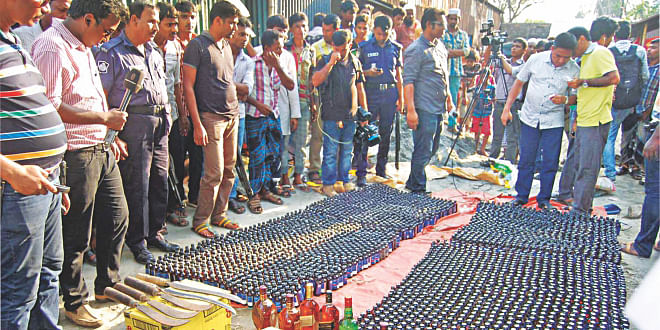 This Star photo taken on May 9 shows policemen displaying seized Phensedyl, foreign liquor and sharp weapons raiding Shimrail Truck Stand in Narayanganj. The contraband substances were recovered from the shops of Nur Hossain, prime accused in the Narayanganj seven-murder case.