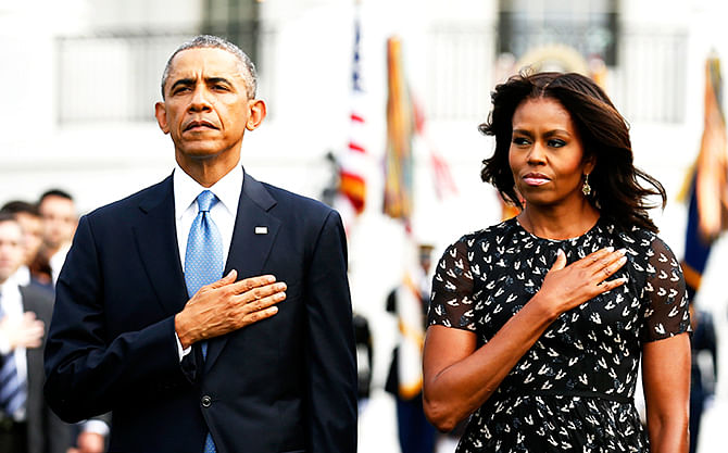 US President Barack Obama and US first lady Michelle Obama observe a moment of silence on the 13th anniversary of the 9/11 attacks at the White House in Washington September 11, 2014. Photo: Reuters
