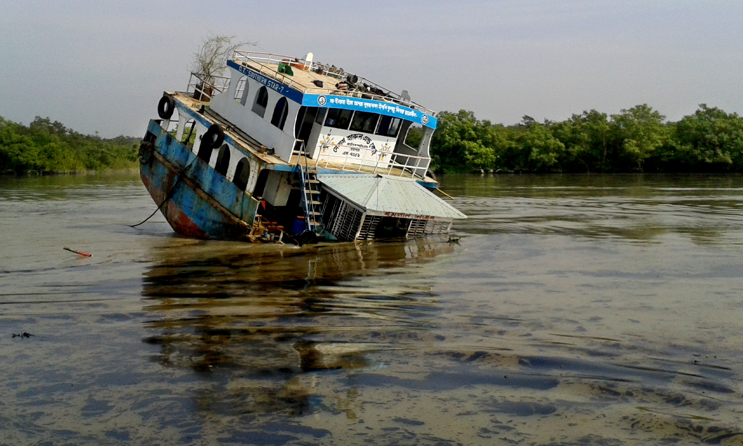 The capsized oil-tanker in Shela river in the Sundarbans spilling dark furnace oil in the river water. Photo: Star
