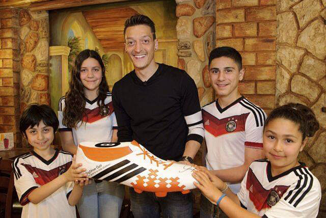 Ozil added a picture on his official Facebook profile showing him with four children holding a large football boot and kitted out in the Germany strip on Wednesday.