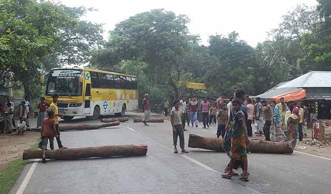 A bus took turns back as Awami League supporters and local people blockade a road felling tree logs Sunday morning in Dharmagram area of Pabna in protest of killing four Awami League men. Photo: Star