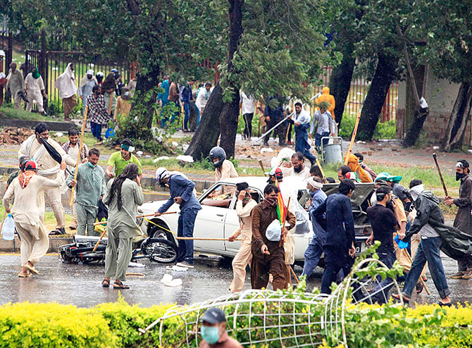 Anti-government protesters use sticks to hit a car and a motorcycle as they protest during Revolution March towards the prime minister's house in Islamabad September 1, 2014. Photo: Reuters