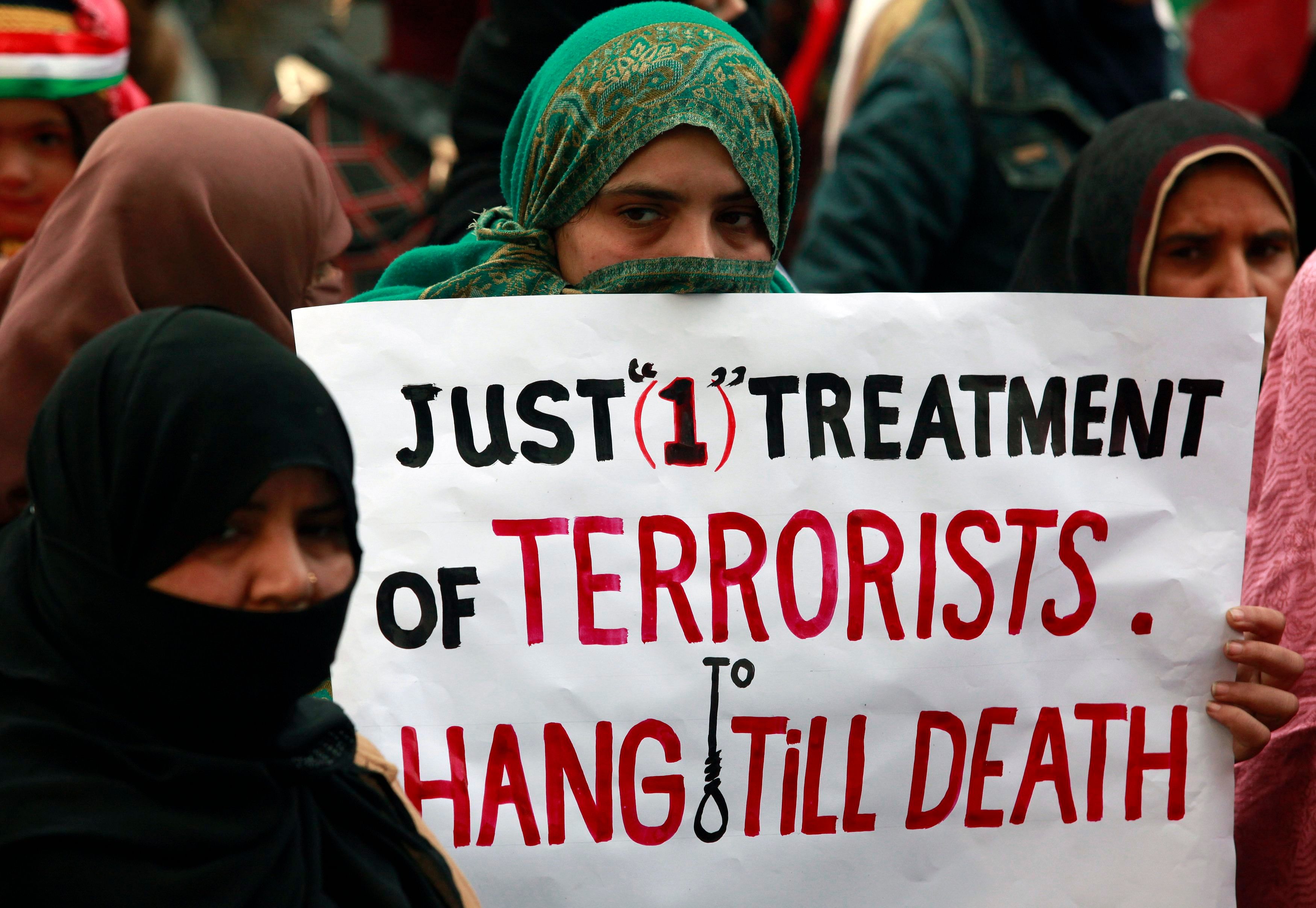 2.	A supporter of political party Pakistan Awami Tehreek (PAT), holds a sign with others to condemn the attack by Taliban gunmen on the Army Public School in Peshawar, during a rally in Lahore December 21, 2014. Photo: Reuters