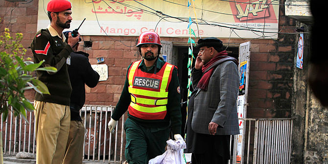 A rescue worker collects evidence from the site of a suicide blast in Rawalpini January 20, 2014. A Taliban suicide bomber killed 10 people in a crowded market on Monday near the Pakistani army headquarters in the city of Rawalpindi, not far from the capital Islamabad, police said.