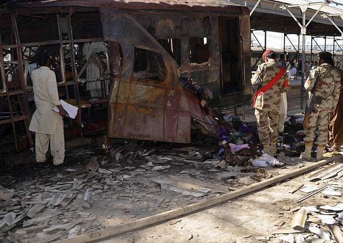 Security officials collect evidence near a damaged messenger carriage at the site of a bomb blast in the town of Sibi April 8, 2014. Fourteen passengers were killed and about 50 wounded on Tuesday when militants bombed a train in Pakistan's Baluchistan province, hospital sources and officials said. Photo: Reuters