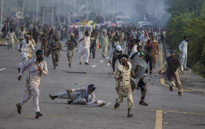 Anti-government protesters run after police personnel during the Revolution March in Islamabad September 1, 2014. Photo: Reuters