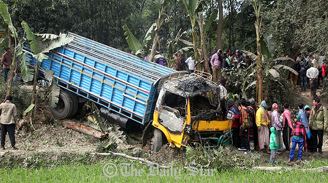 A truck falls into a roadside ditch after alleged blockaders torch it hurling petrol bomb on Dhaka-Barisal highway in Uzirpur upazila of Barisal Sunday morning. Helper of the vehicle burnt to death in the petrol bomb attack. Photo: STAR