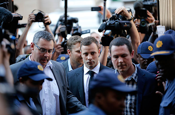 South African Olympic and Paralympic track star Oscar Pistorius (C) arrives for the verdict in his murder trial at the high court in Pretoria September 10,  2014. Pistorius, the double amputee who became one of the biggest names in athletics, shot dead his model and law graduate girlfriend Reeva Steenkamp on Valentine's Day last year. Photo: Reuters