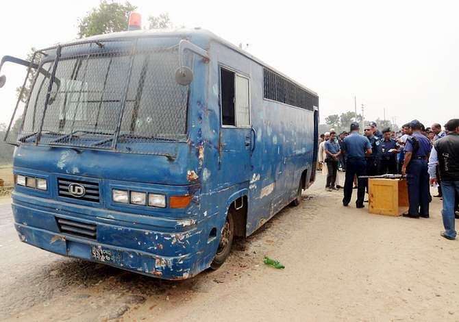 This February 23 photo shows policemen scrunitising clues near a prison van in Trishal upazila of Mymensingh where an armed gang ambushed the vehicle and snatched away three convicted JMB militants. Photo: Banglar Chokh