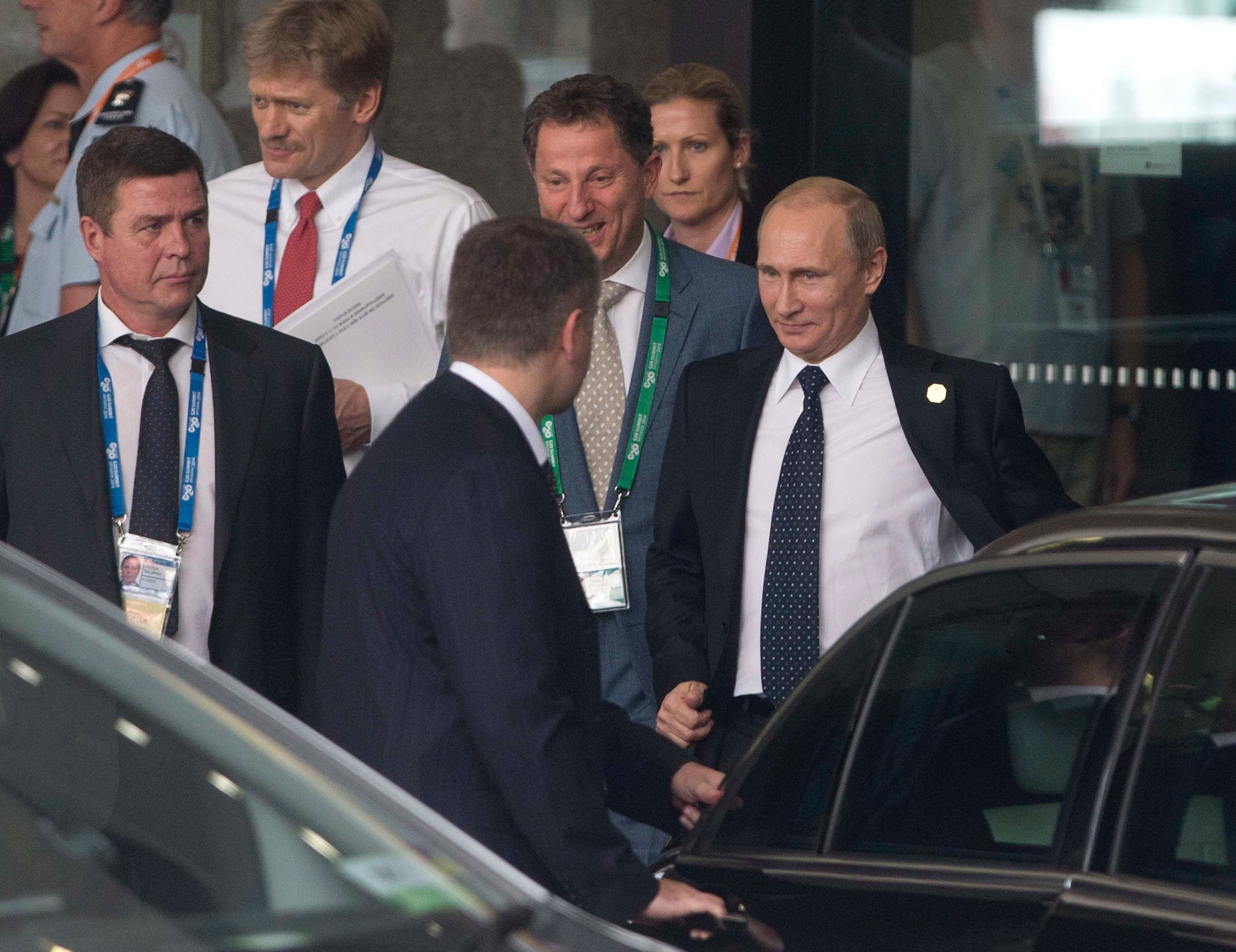 Russian President Vladimir Putin takes off his jacket as he leaves his hotel en route to Brisbane Airport as he leaves the G20 leaders summit early, November 16, 2014. Photo: Reuters