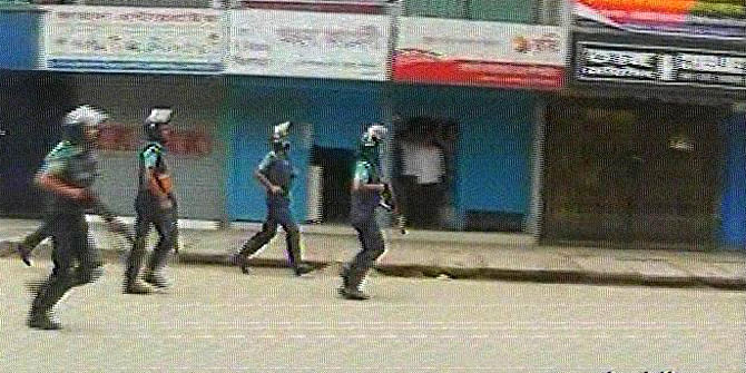 Law enforcers chase activists of Jamaat-e-Islami and its student wing Islami Chhatra Shibir during a clash near Loknath School in Rajshahi city Saturday morning. Photo: TV grab 