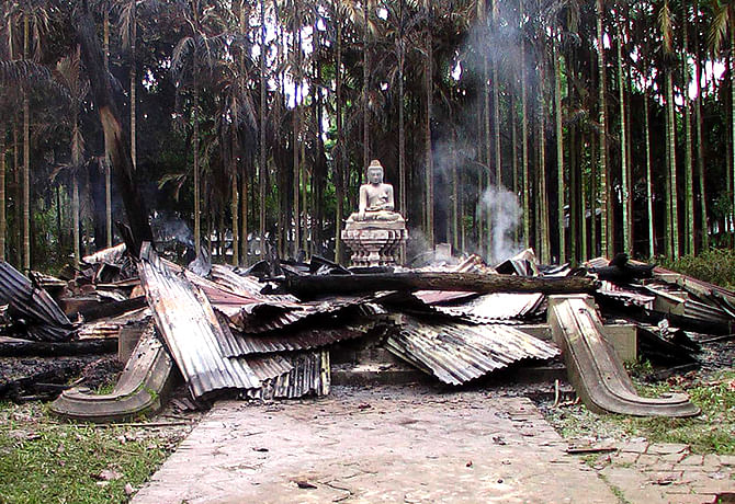 This Star photo taken on September 30, 2012 shows a statue of Lord Buddha is left standing amidst the ruins of a temple burnt down by a violent mob at Ramu upazila in Cox's Bazar.