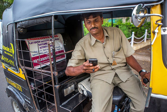 Now with Autowale, Praveen Narayan Dusane simply checks text messages on his cellphone for his schedule, with pickups usually coming every hour or so. Photo: The New York Times