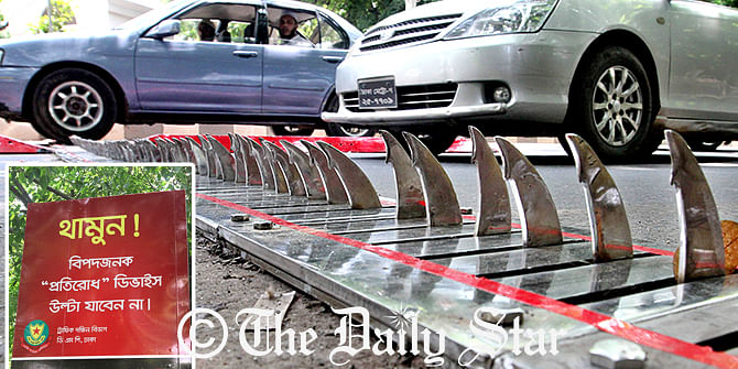 Cars are passing over the spikes in Hare road area in the capital on Friday. The retractable spikes were installed in the morning to prevent traffic going the wrong way. Photo: Anisur Rahman