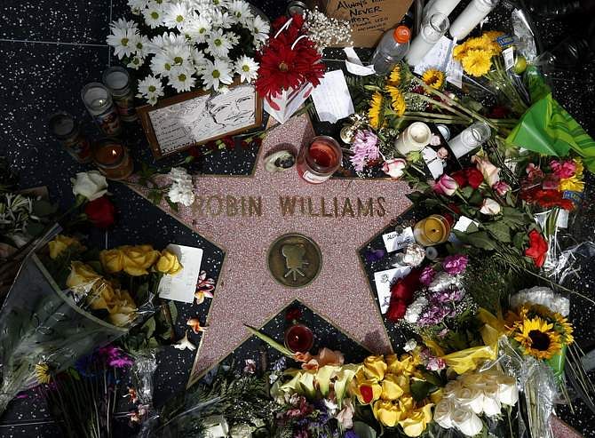 Flowers are seen on the late Robin Williams' star on the Hollywood Walk of Fame in Los Angeles, California August 12, 2014. Comedians, politicians and several generations of fans collectively mourned on Tuesday the death of Robin Williams, the actor famous for his frenetic and freewheeling comedy whose apparent suicide at age 63 prompted an outpouring of tributes. Photo: Reuters
