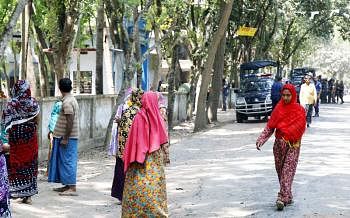 People turn back from their way to Agardari Kamil Madrassa polling in Satkhira Sadar upazila on Monday. Two police vans and law enforcers are seen gathered on a road in the area. Photo courtesy of Prothom Alo 