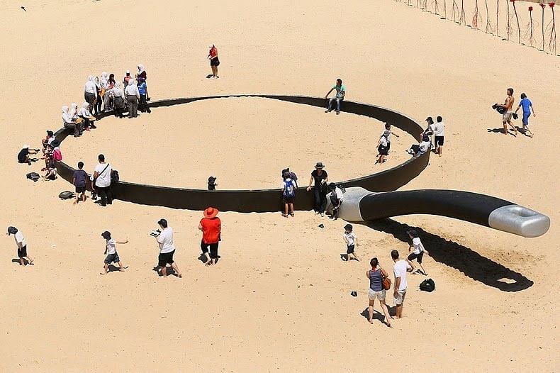 School children play on the sculpture We're Fryin' Out Here by Andrew Hankin on Tamarama Beach. Photo taken from Amusing Planet/ Cameron Spencer