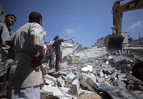 Palestinian rescuers search for bodies and survivors in the rubble of homes which were destroyed by an Israeli missile strike, in Gaza City, Monday. Photo: AP 