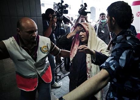 Palestinians escort a wounded woman to the emergency room of Shifa hospital in Gaza City, northern Gaza Strip, Sunday. Photo: AP