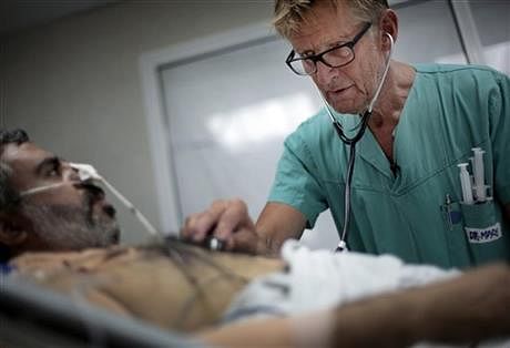 In this Wednesday, July, 16, 2014, Mads Gilbert, Norwegian doctor who has volunteered at Shifa on and off for 17 years, treats a man at the emergency room of the Shifa hospital in Gaza City. Photo: AP