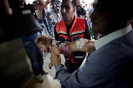 A Palestinian medic carries an injured girl to an emergency room at Shifa hospital in Gaza City, Sunday. Photo: AP