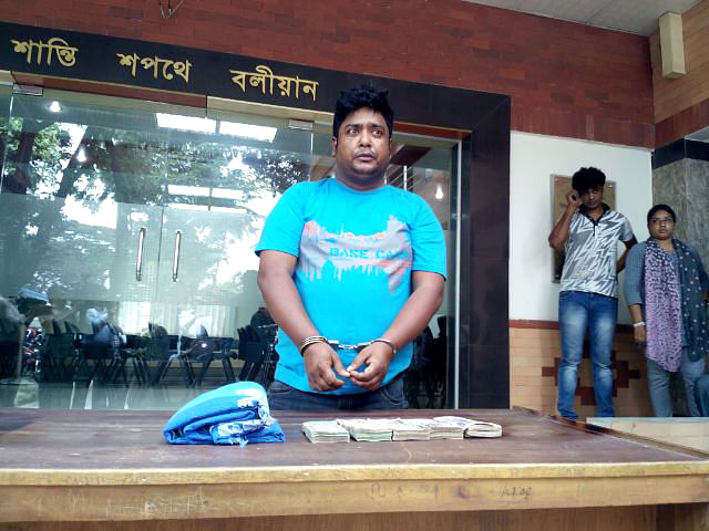 Detective Branch of Police members produce Kazi Sirajul Isalm, an alleged mugger, before media at the DMP Media Centre in Dhaka on Monday. Photo: Star