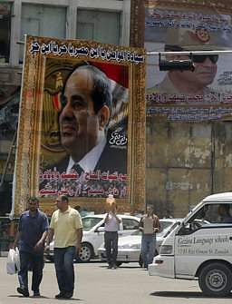 People walk near huge banners for Egypt's former army chief Field Marshal Abdel Fattah al-Sisi in downtown Cairo April 28, 2014. Photo: Reuters