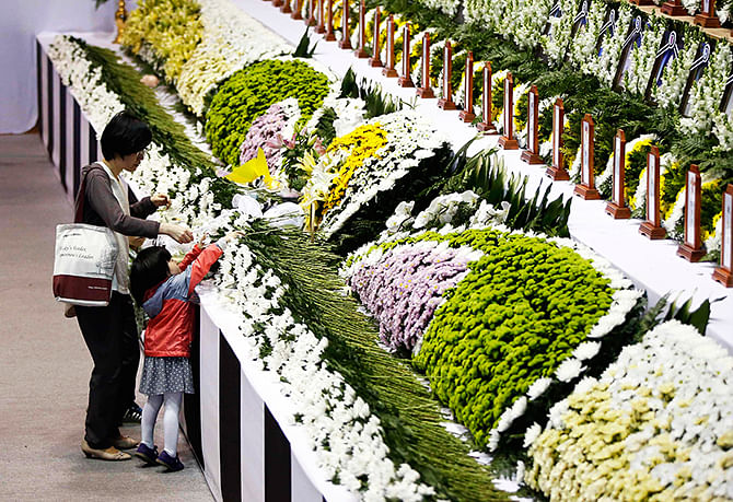 A family member pays floral tribute at a temporary group memorial altar for victims of capsized passenger ship Sewol in Ansan April 26, 2014. Photo: Reuters
