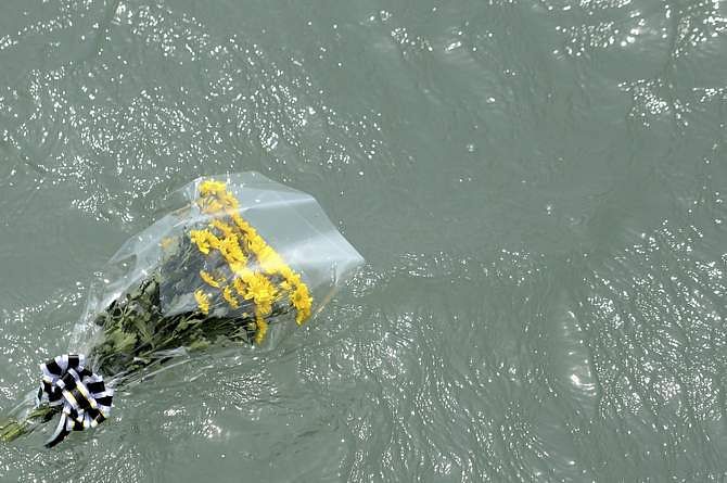 Flowers dedicated by family members to missing and dead passengers of sunken passenger ship Sewol float on the sea in Jindo May 2, 2014. Photo: Reuters