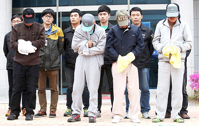 Crew members (front row) of the sunken Sewol ferry stand outside a court in Mokpo, after investigators sought for warrants of their arrest at the court April 26, 2014. Photo: Reuters