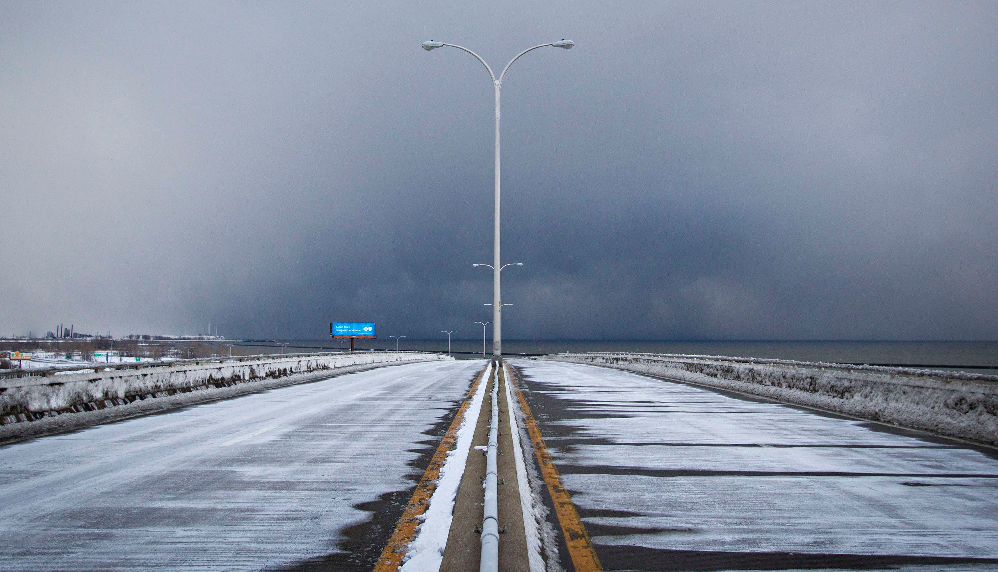 Storm clouds and snow blow from Lake Erie over the still-closed Route 5 highway in Lackawanna, near Buffalo, New York November 20, 2014. Photo: Reuters