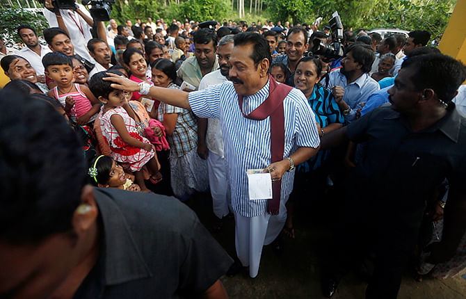 Sri Lanka's President Mahinda Rajapaksa greets supporters after casting his vote for the presidential election, in Medamulana, January 8, 2015. Photo: Reuters