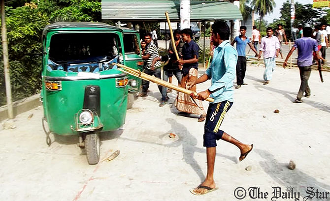 Bus workers vandalise the CNG-run auto-rickshaws at Kadamtali area in Sylhet protesting the vandalism of buses on Saturday. Photo: Star 