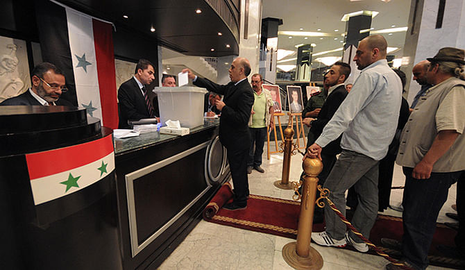 A man casts his vote as others wait for their turn at the Dama Rose hotel during the presidential election in Damascus, June 3, 2014. Photo: Reuters