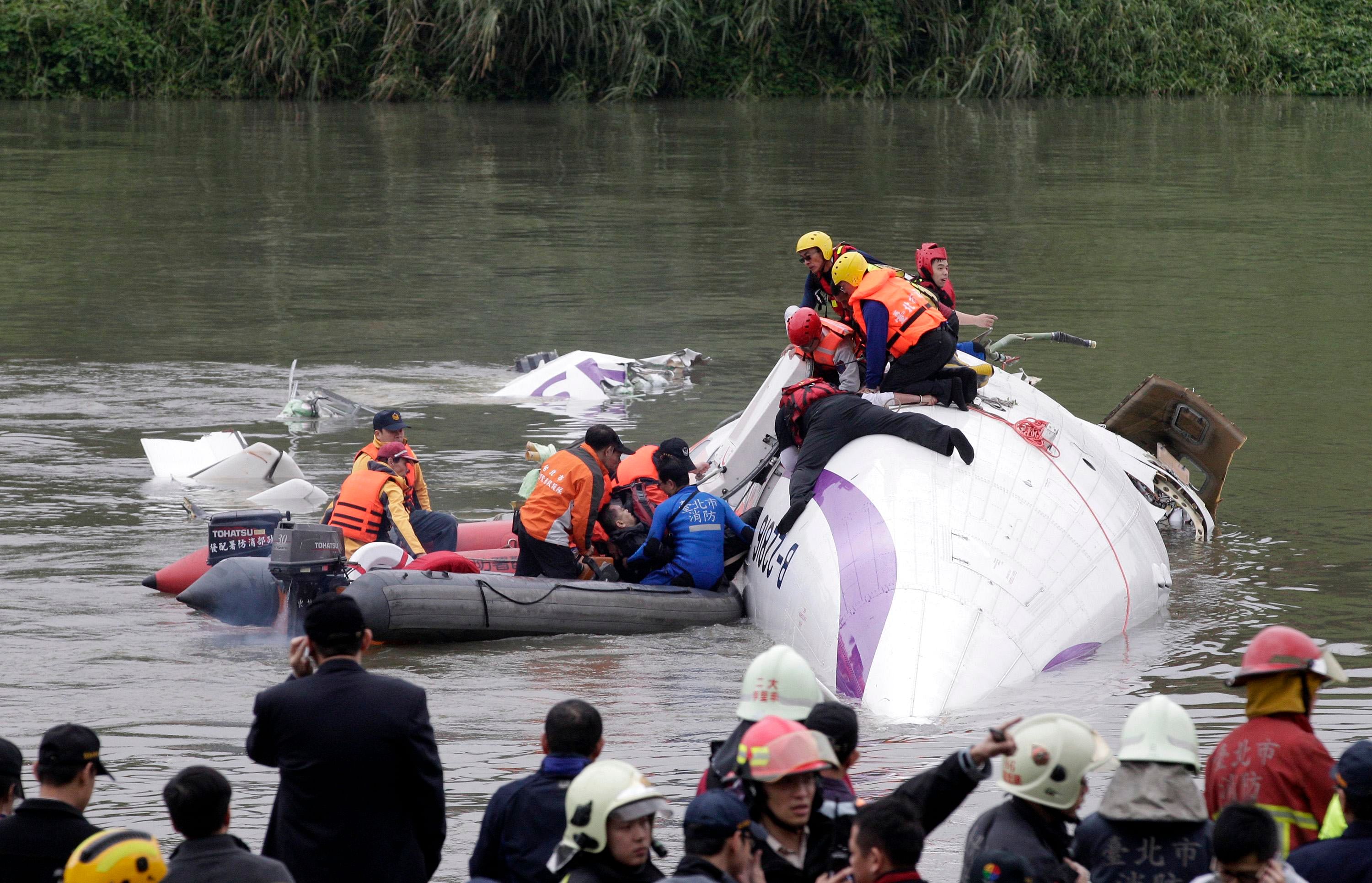 Rescuers pull a passenger out of the TransAsia Airways plane which crash landed in a river, in New Taipei City, February 4, 2015. Photo: Reuters