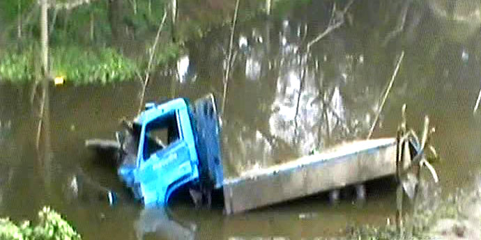 A damaged truck lies in a roadside ditch in Basail upazila of Tangail. The vehicles fell there after being hit by a Dhaka-bound train on Friday morning. Two persons were killed and 12 injured in the accident.