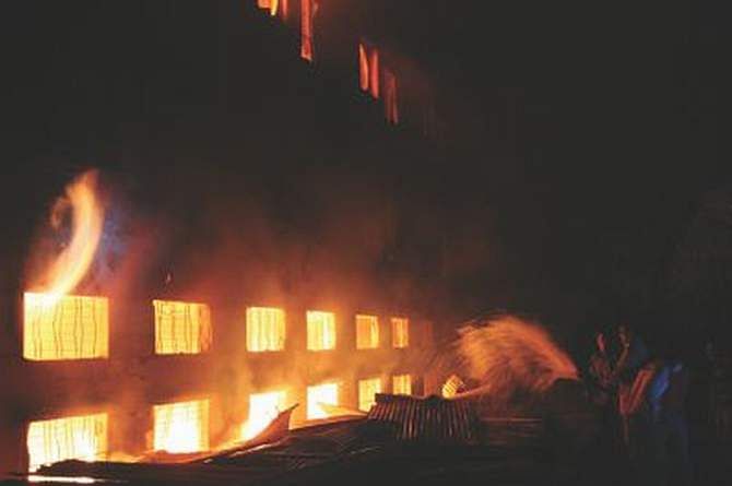 Locals try to douse the flames in Tazreen Fashion near Dhaka Export Processing Zone in Ashulia on November 24, 2012. The fire gutted several floors of the eight-storied factory and at least 113 workers were killed in the incident. Photo: STAR