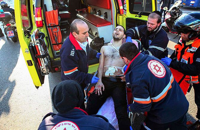 Israeli medics wheel a wounded man to an ambulance at the scene of a stabbing attack in Tel Aviv January 21, 2015. A Palestinian man stabbed up to 10 people on a commuter bus in central Tel Aviv on Wednesday before he was shot in the leg by a prison security officer as he tried to escape, police said. Photo: Reuters