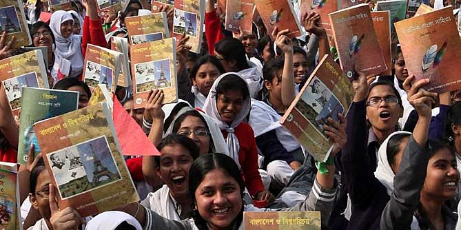 This January 1 photo shows students cheering with new textbooks at their school premises in the capital.