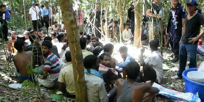 Thailand police rescue a group of Bangladeshi nationals at a rubber plantaion of the country's southern part on October 11. The arrestees were trafficked into the country illegally. Photo grabbed from BBC video