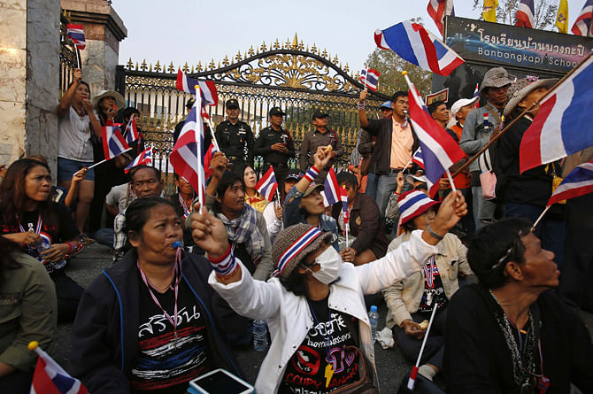 Anti-government protesters sit outside a polling station in central Bangkok on January 26, 2014. Thai authorities told anti-government protesters on Saturday to stop blockading official buildings and not to interfere in early voting in a general election on Sunday, but promised not to use violence to clear Bangkok streets. 