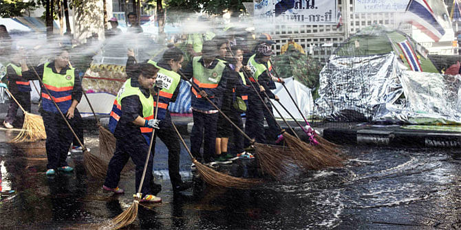 City workers clean the street where anti-government protesters are camping in Bangkok's shopping district January 28, 2014. 