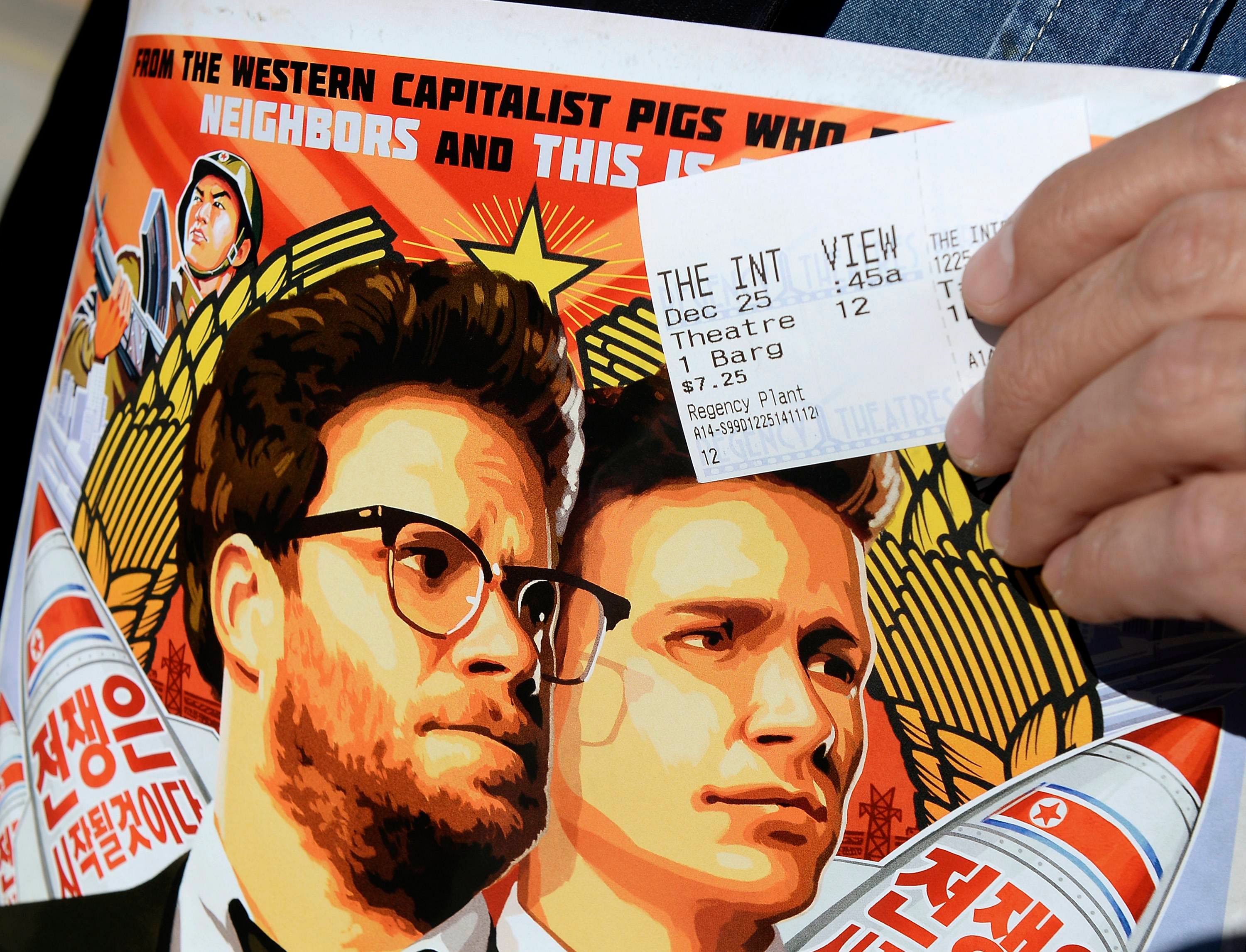 Dennis Lavalle holds a ticket and a poster of the film "The Interview" starring actors Seth Rogen and James Franco as he attends the Christmas Day screening of "The Interview" in the Van Nuys section of Los Angeles, California December 25. Photo: Reuters