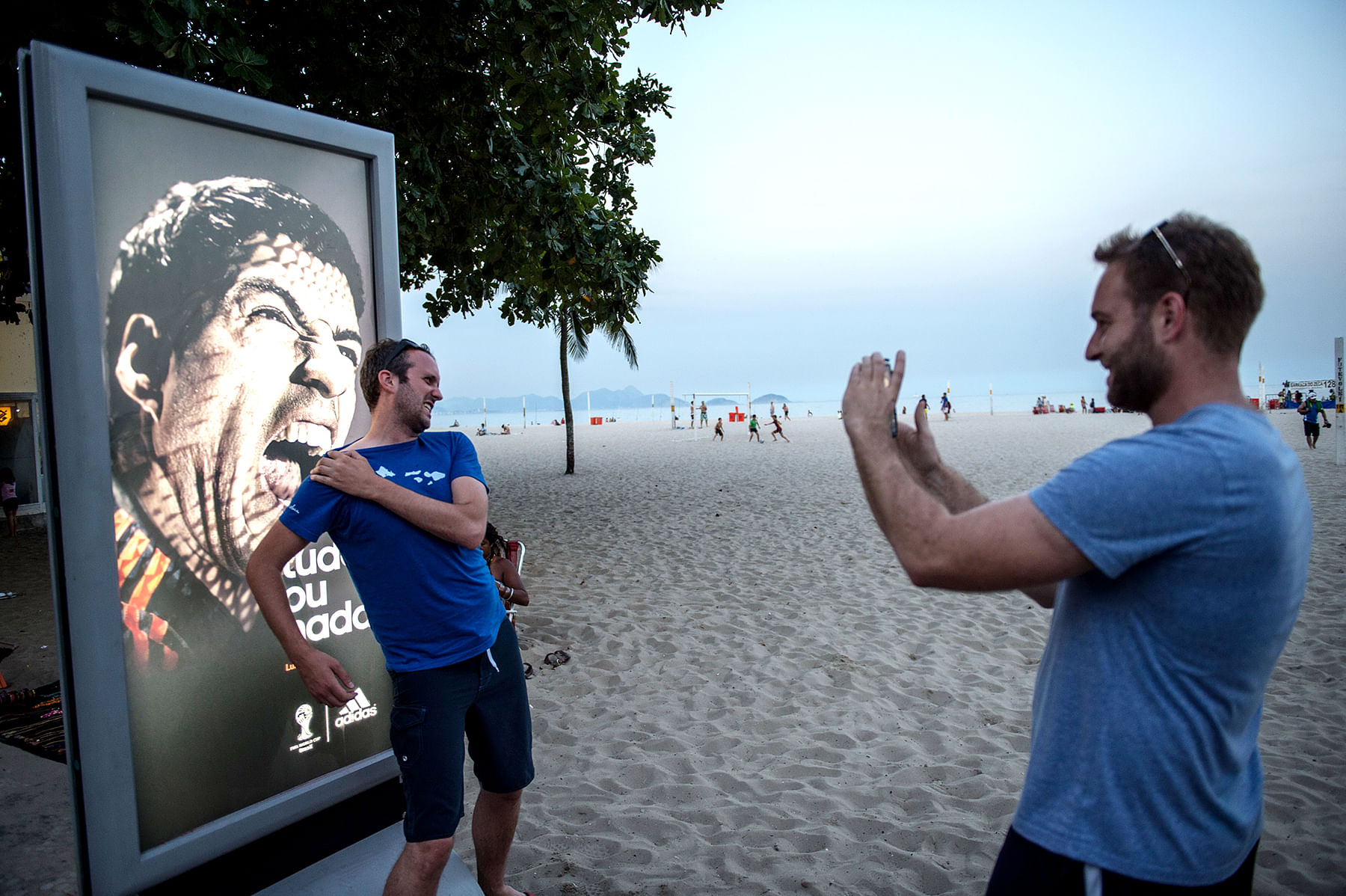 Tourists joke in front of an advertisement with the portrait of Uruguay's forward Luis Suarez at Copacabana beach in Rio de Janeiro, Brazil, on June 26, 2014. Photo: AFP/Getty Images