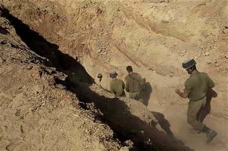 In this October 13, 2013 file photo, Israeli soldiers enter a tunnel discovered near the Israel Gaza border. Photo: AP