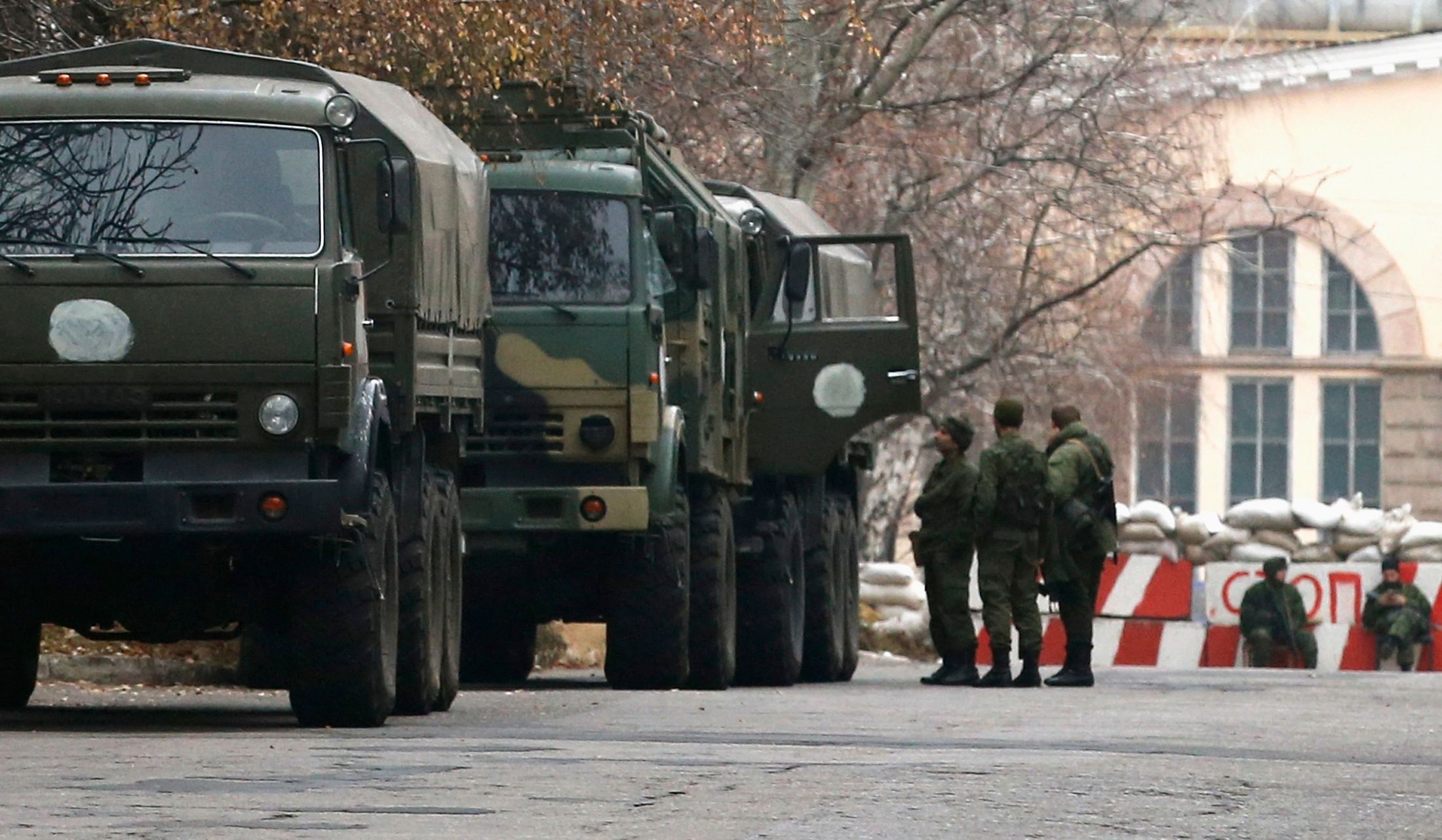 Armed people and military trucks are seen near a checkpoint outside a building on the territory controlled by the self-proclaimed Donetsk People's Republic in Donetsk, eastern Ukraine, 12 November, 2014. Photo: Reuters