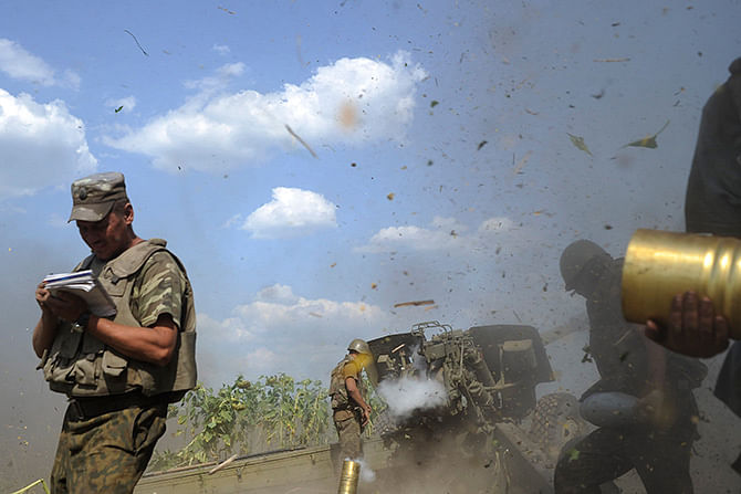 Ukrainian servicemen, who are members of an artillery section, gather near a cannon being fired during a military operation against pro-Russian separatists near Pervomaisk, Luhansk region August 2, 2014. Reuters