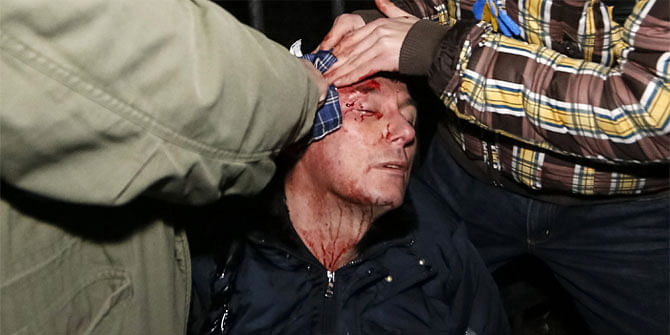 Former Ukrainian interior and opposition leader minister Yuriy Lutsenko receives medical help after clashes with riot police near a court in Kiev January 10, 2014. The activists were protesting against a court decision regarding several activists accused of terrorism, local media reported. 
