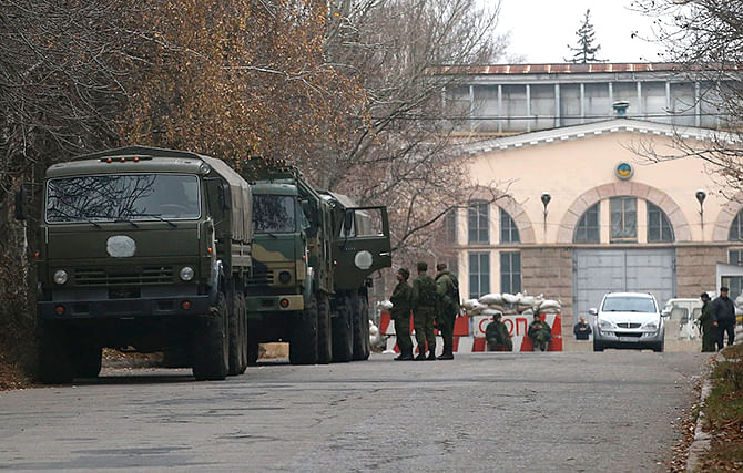 Armed people and military trucks are seen near a checkpoint outside a building in the territory controlled by the self-proclaimed Donetsk People's Republic in Donetsk, eastern Ukraine, November 12, 2014. Photo: Reuters