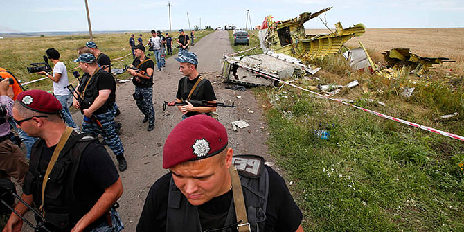 Armed pro-Russian separatists stand guard at a crash site of Malaysia Airlines Flight MH17, near the village of Hrabove, Donetsk region July 20, 2014. Photo: Reuters
